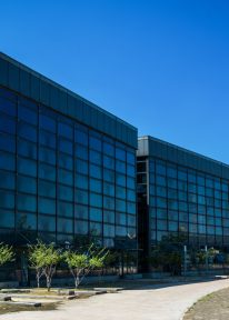 Modernes Bürogebäude mit einem blauen Hintergrund.

Modern office building with a blue sky on the background.